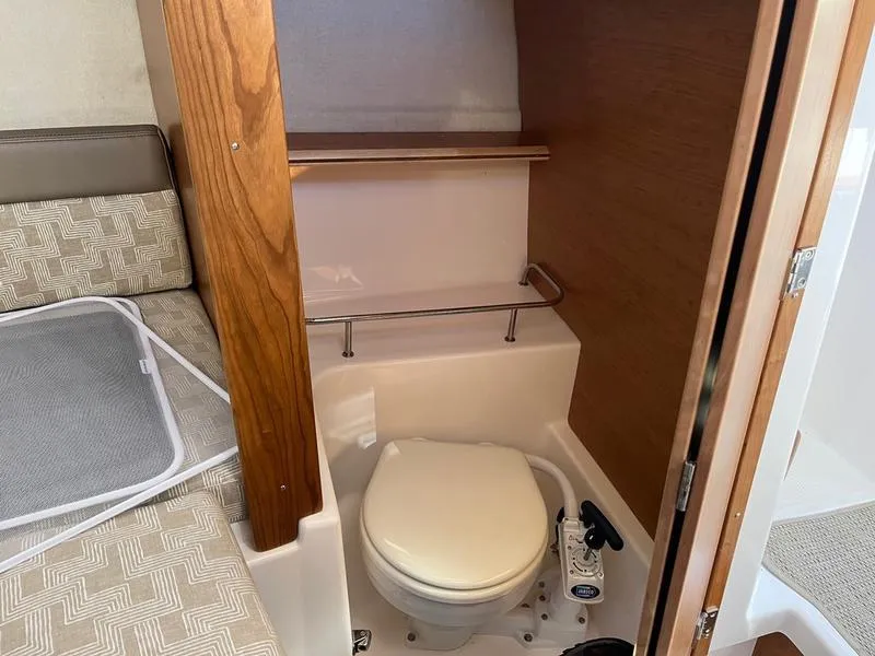 Slide: The Image of 2025 Cutwater C-248 C Coupe boat interior with compact bathroom and toilet. - 6