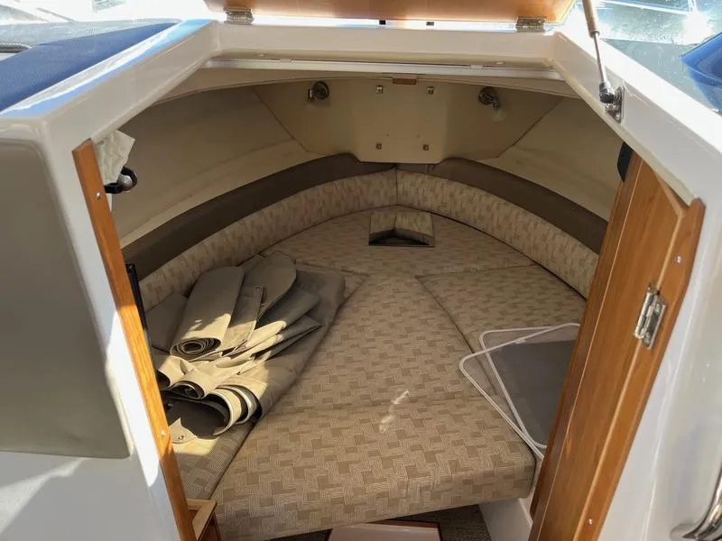 Slide: The Image of 2025 Cutwater C-248 C Coupe cabin interior with beige cushions and wooden accents. - 7