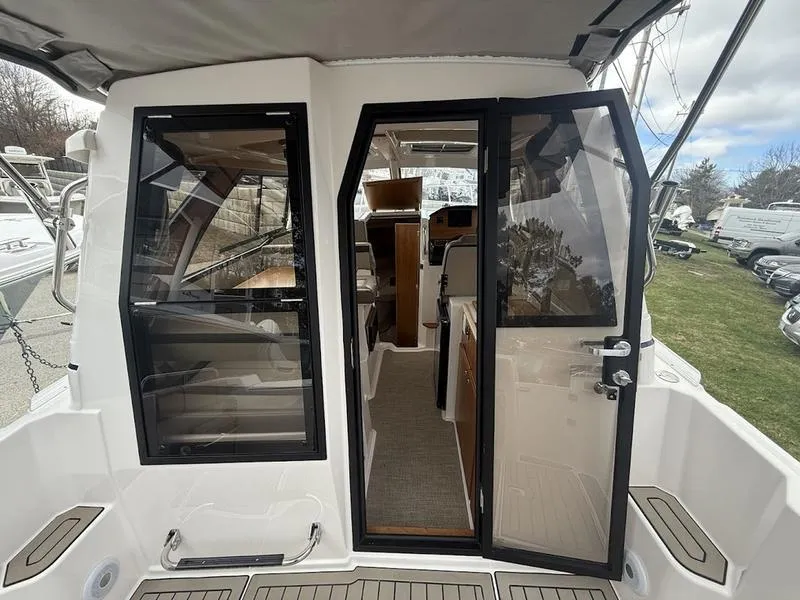 Slide: The Image of 2025 Cutwater C-248 C Coupe boat interior view with open glass doors. - 12