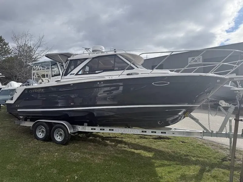 Slide: The Image of 2025 Cutwater C-248 C Coupe boat on trailer, parked outdoors under cloudy sky. - 3
