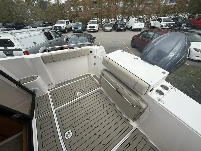 Slide: The Image of 2025 Cutwater C-248 C (COUPE) boat deck with seating and storage, parked in a lot. - 8