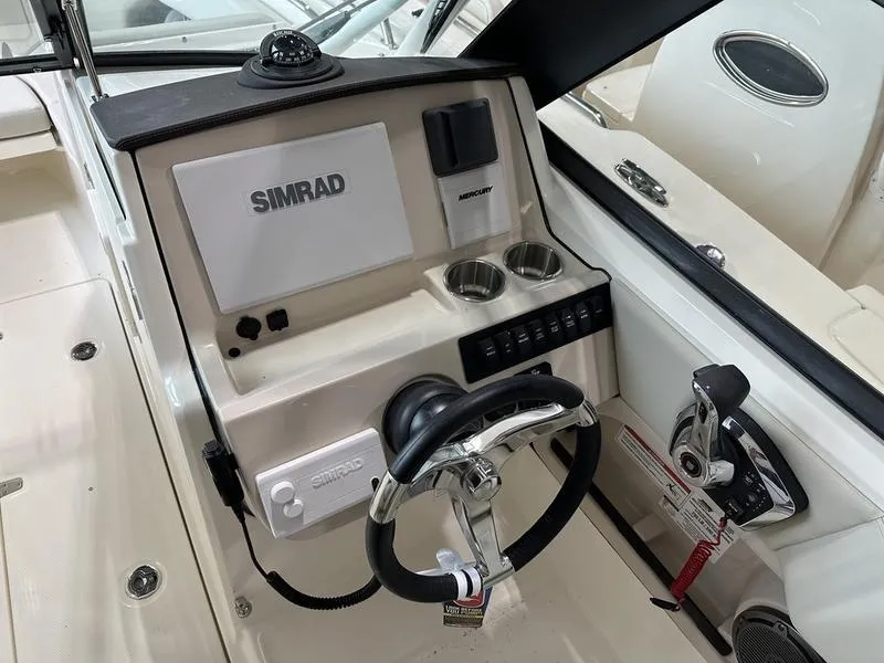 Slide: The Image of 2024 Boston Whaler 240 Vantage helm with Simrad navigation system and steering wheel. - 10