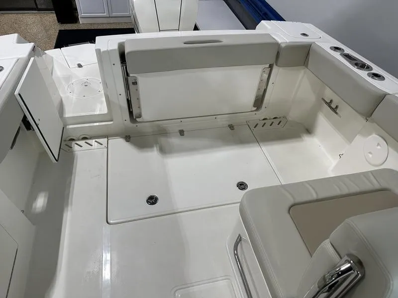 Slide: The Image of 2024 Boston Whaler 240 Vantage boat interior with white seating and storage compartments. - 5