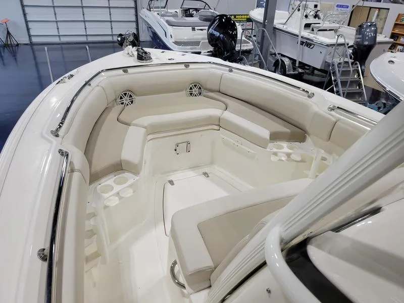 Slide: The Image of 2025 Boston Whaler 230 Outrage boat interior with cushioned seating and cup holders. - 12