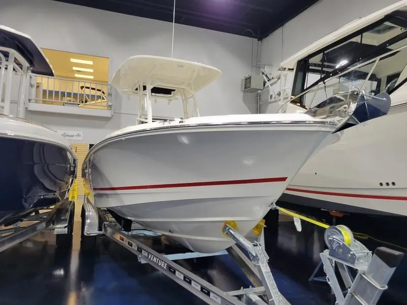 Slide: The Image of 2025 Boston Whaler 230 Outrage boat on trailer in showroom. - 5