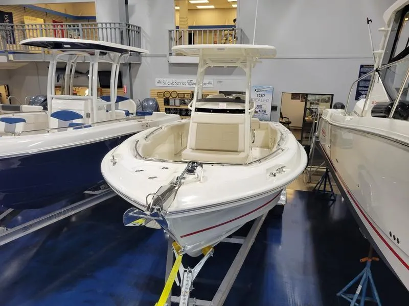 Slide: The Image of 2025 Boston Whaler 230 Outrage boat displayed in showroom. - 6