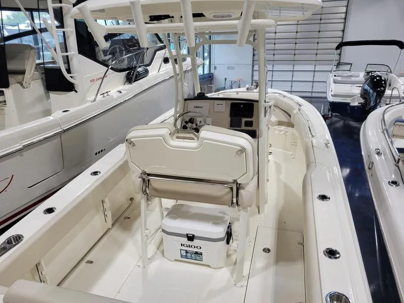 Slide: The Image of 2025 Boston Whaler 230 Outrage boat interior with seating and cooler. - 7