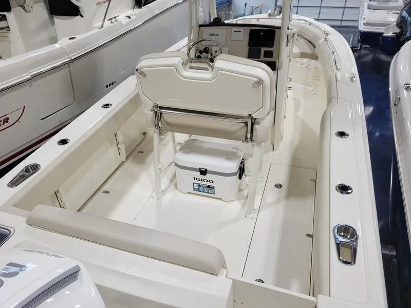 Slide: The Image of 2025 Boston Whaler 230 Outrage boat interior with seating and cooler. - 8