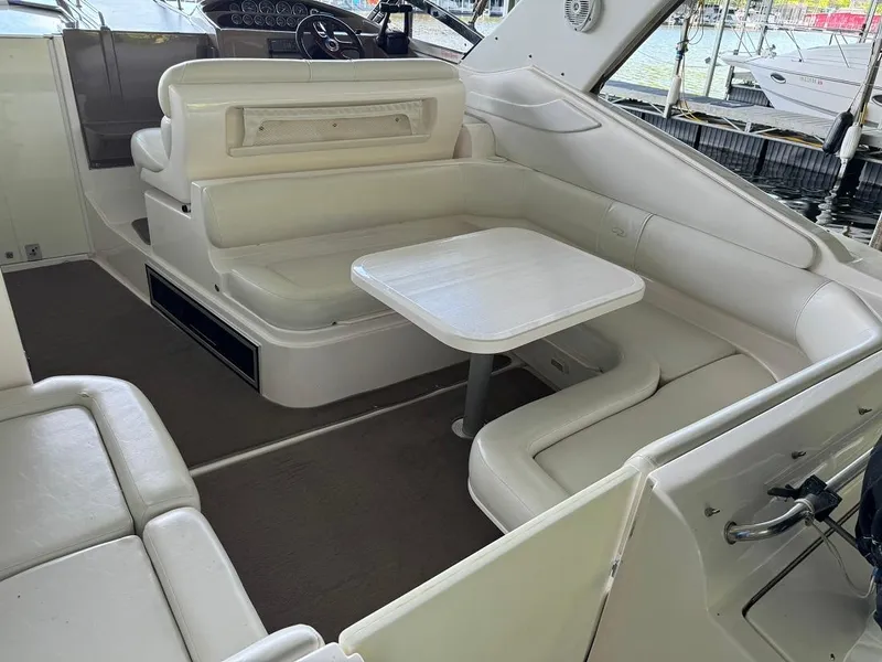 Slide: The Image of 2004 Regal 3260 Commodore boat interior with white seating and table. - 13