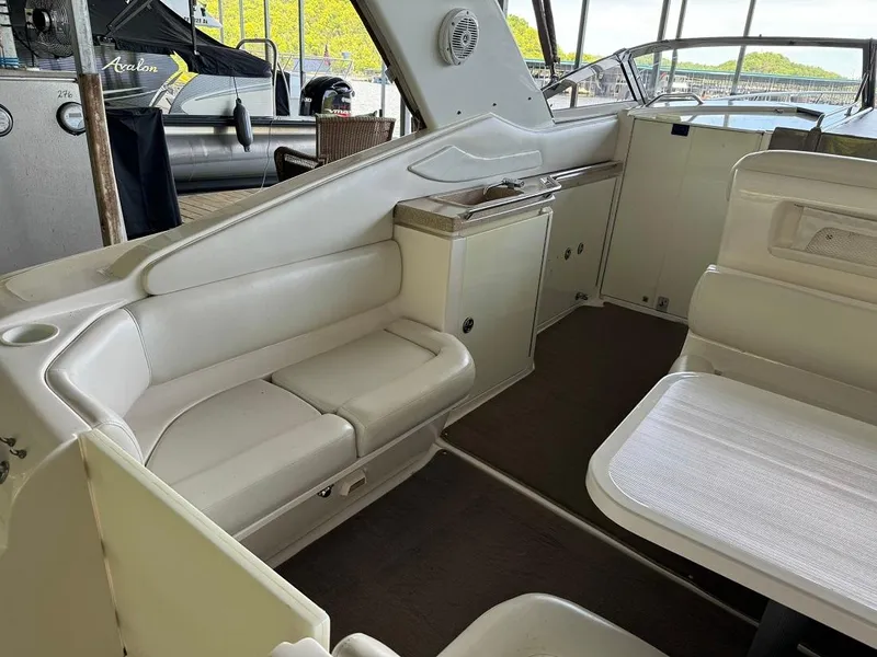 Slide: The Image of 2004 Regal 3260 Commodore boat interior with white seating and table. - 14