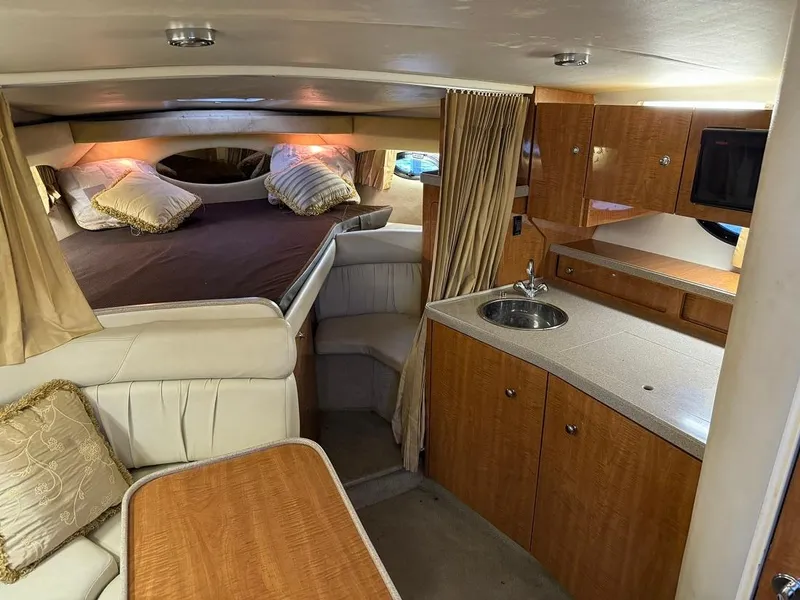 Slide: The Image of 2004 Regal 3260 Commodore interior with bed, kitchenette, and seating area. - 27