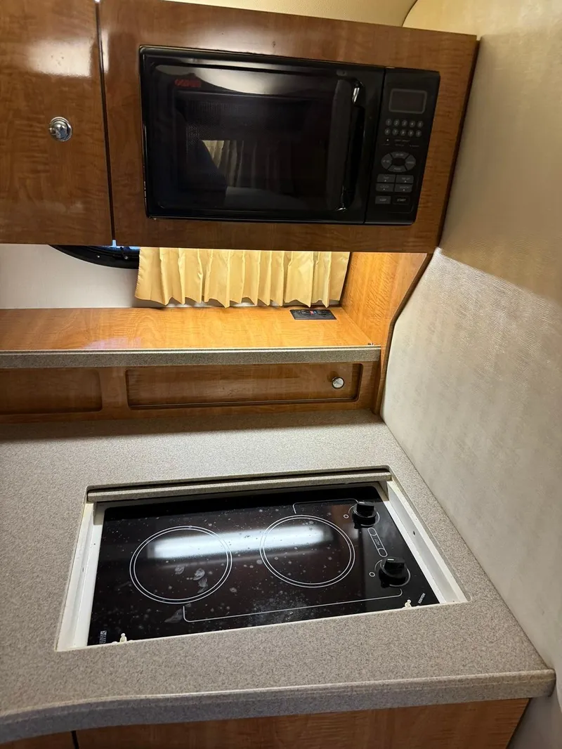 Slide: The Image of 2004 Regal 3260 Commodore kitchen with microwave and stovetop. - 29