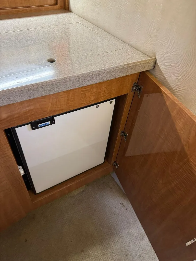 Slide: The Image of 2004 Regal 3260 Commodore boat interior with mini fridge and wooden cabinetry. - 30