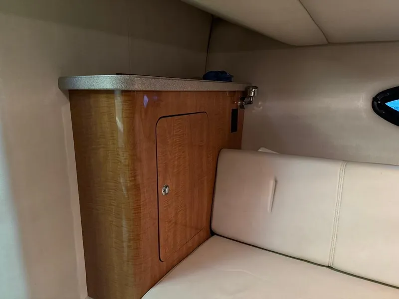 Slide: The Image of Interior cabin of 2004 Regal 3260 Commodore with wooden cabinet and white seating. - 42