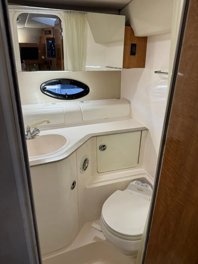 Slide: The Image of 2004 Regal 3260 Commodore yacht bathroom with sink, toilet, and mirror. - 43