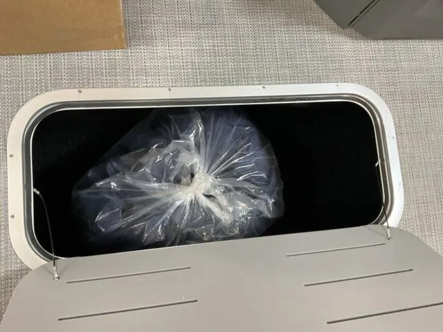 Slide: The Image of Storage compartment of 2024 Bennington 22 SVL with a plastic bag inside. - 18