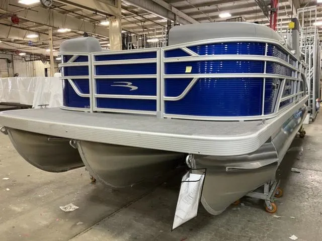 Slide: The Image of 2024 Bennington 22 SVL pontoon boat with blue cover in a warehouse. - 3