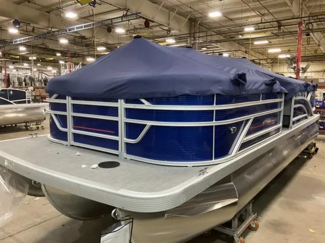 Slide: The Image of 2024 Bennington 22 SVL pontoon boat with blue cover in a warehouse. - 4