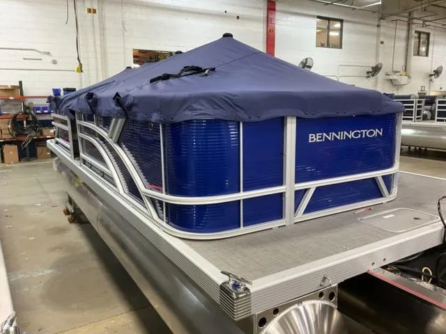 Slide: The Image of 2024 Bennington 22 SVL pontoon boat with blue cover in a warehouse. - 5