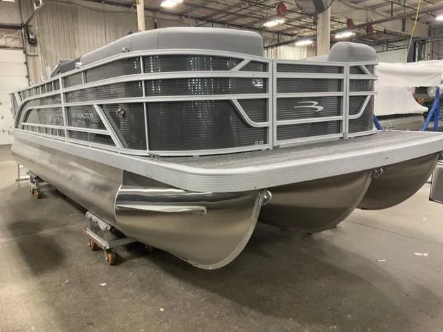Slide: The Image of 2024 Bennington 22 SVS pontoon boat with black cover in a warehouse. - 3