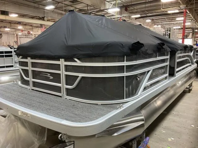 Slide: The Image of 2024 Bennington 22 SVS pontoon boat with black cover in a warehouse. - 4