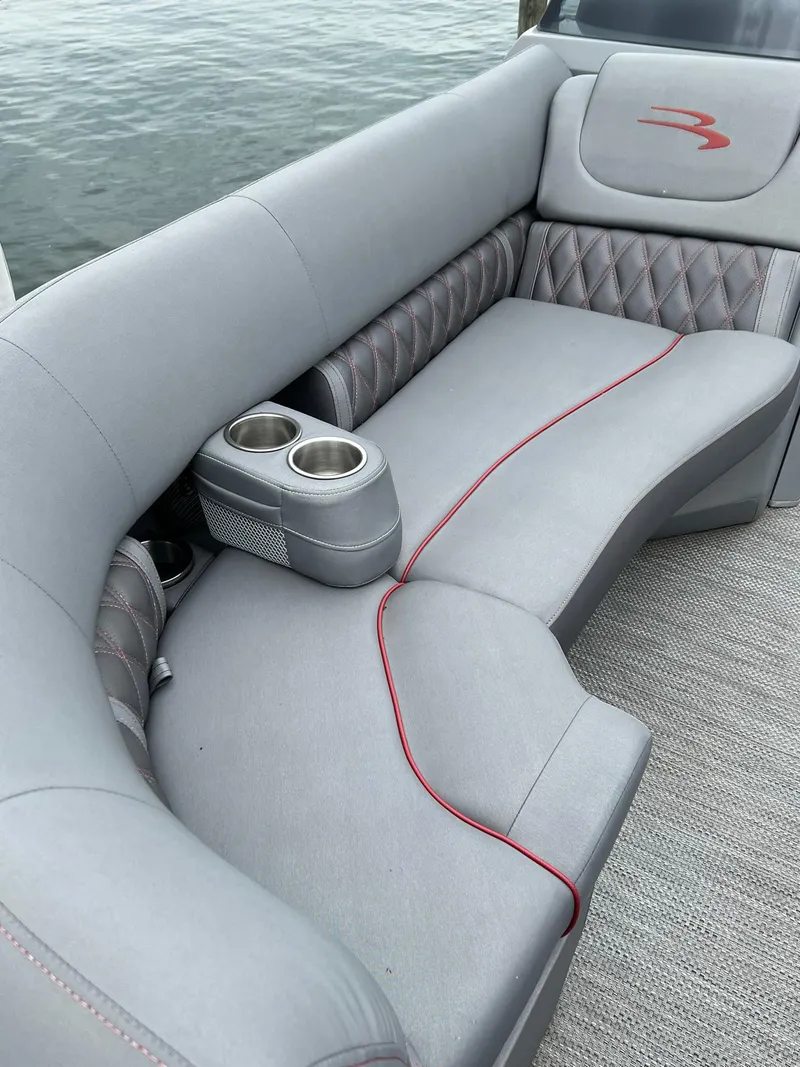 Slide: The Image of 2022 Bennington 24 LXFB boat interior with gray seating and cup holders. - 14