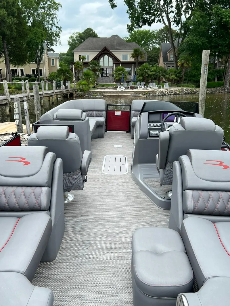 Slide: The Image of 2022 Bennington 24 LXFB pontoon boat with luxurious seating and waterfront view. - 18