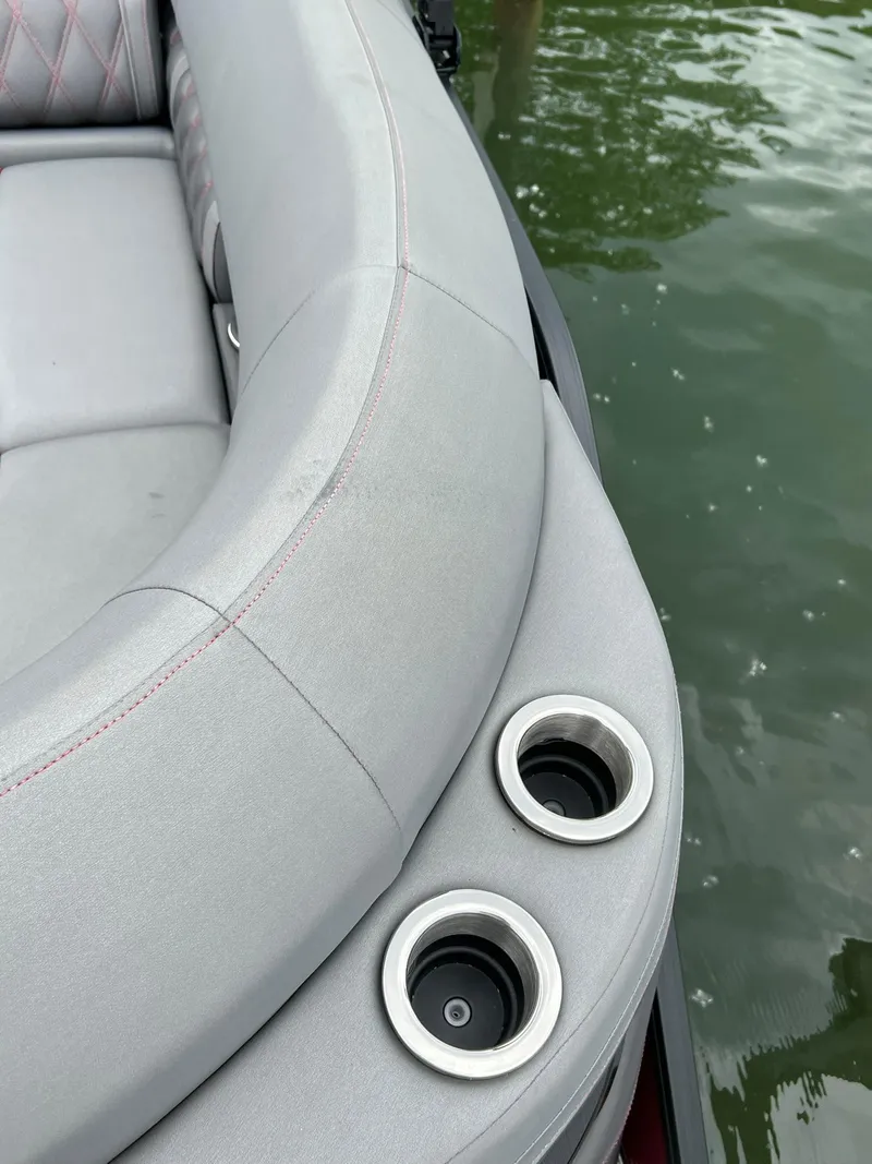 Slide: The Image of Close-up of 2022 Bennington 24 LXFB boat's cushioned seating and cup holders. - 19