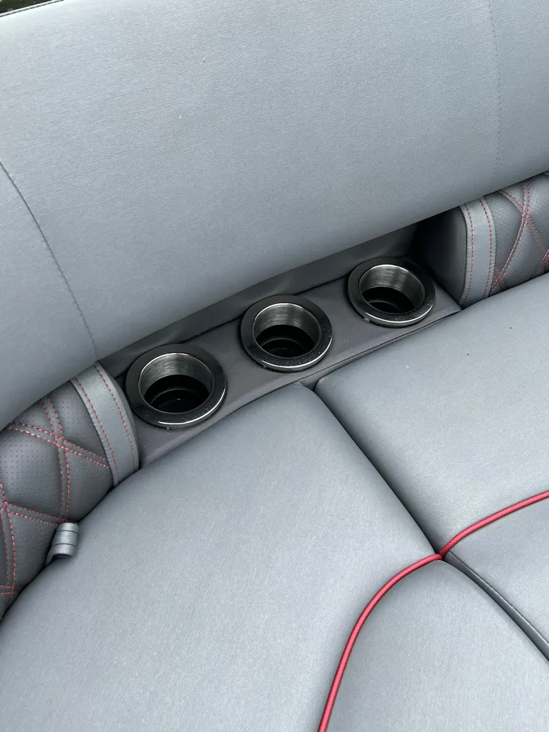Slide: The Image of 2022 Bennington 24 LXFB boat interior with cup holders and grey upholstery. - 20