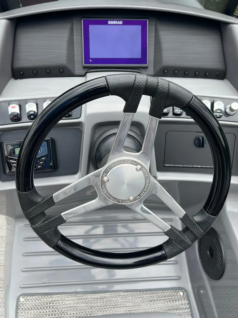 Slide: The Image of 2022 Bennington 24 LXFB boat steering wheel and dashboard with Simrad display. - 7