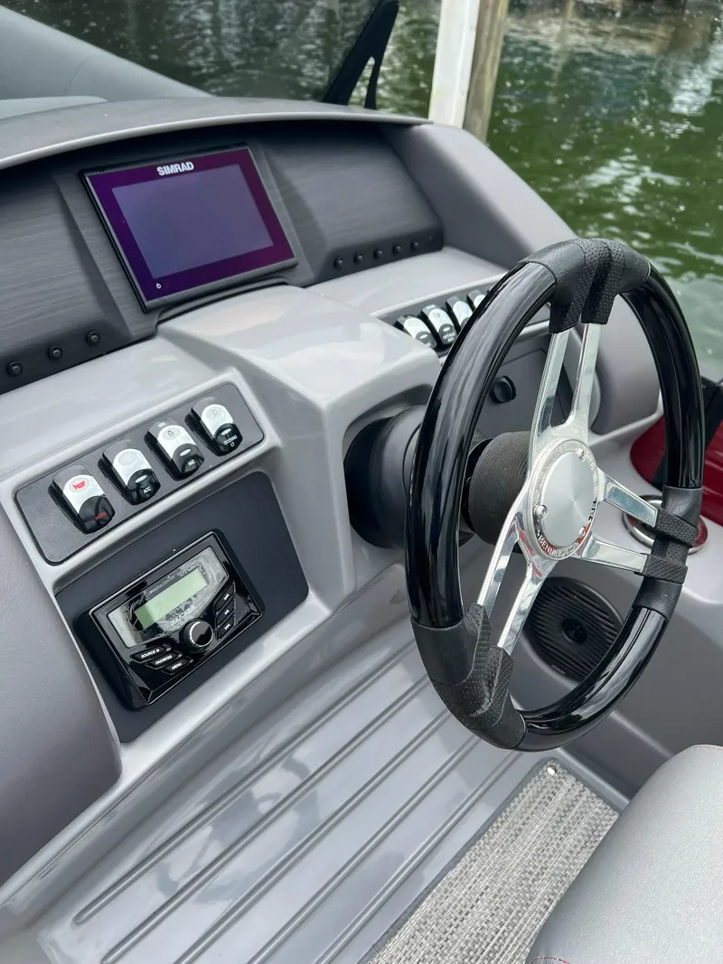 Slide: The Image of 2022 Bennington 24 LXFB boat dashboard with steering wheel and control panel. - 9