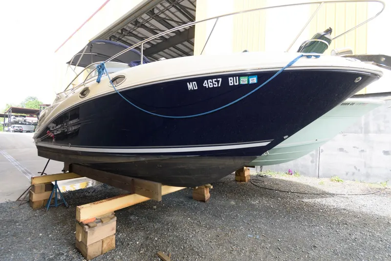 The Image of 2005 Sea Ray 260 Sundancer boat on wooden blocks in a storage facility. - 0