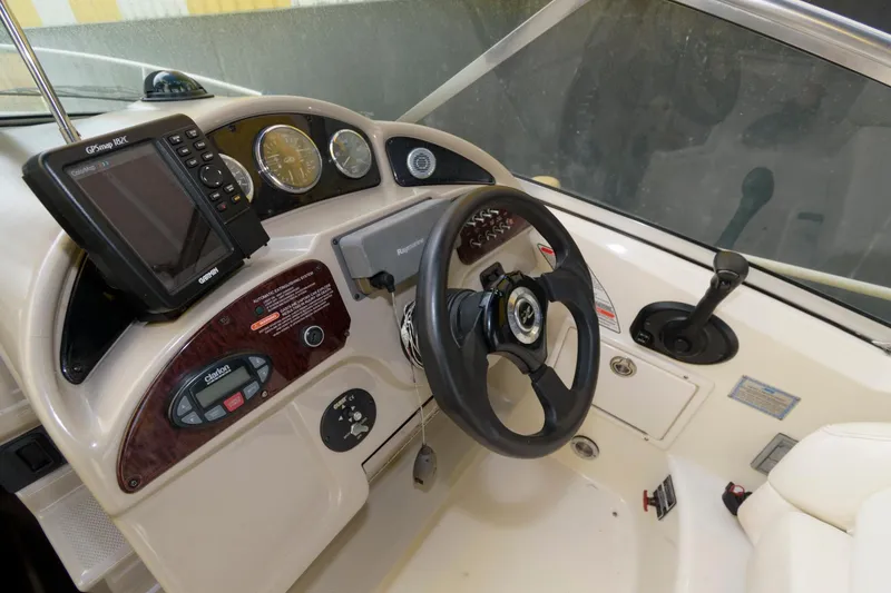 Slide: The Image of 2005 Sea Ray 260 Sundancer helm with steering wheel, gauges, and navigation system. - 6