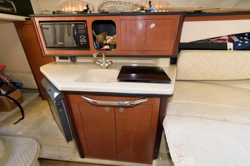 Slide: The Image of Compact kitchen area in a 2005 Sea Ray 260 Sundancer boat with sink and microwave. - 8