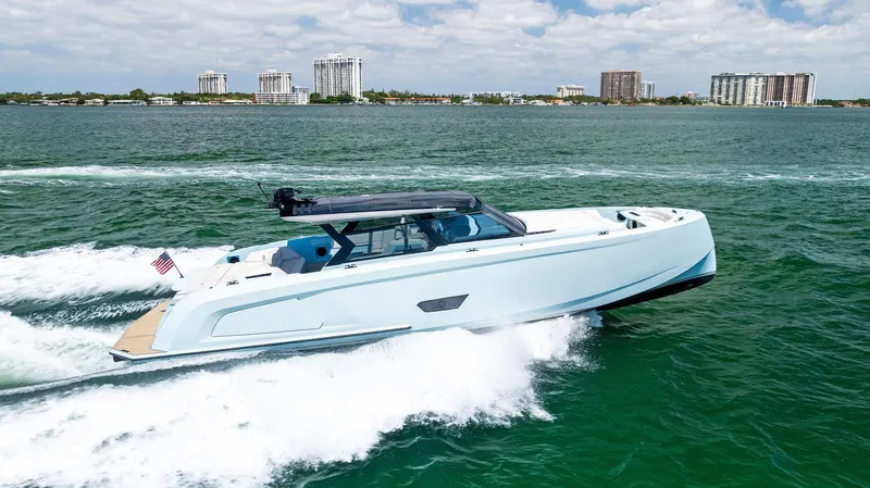 Slide: The Image of 2022 Vanquish Yachts VQ58 cruising on open water with city skyline in background. - 0