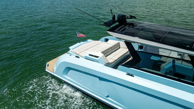 Slide: The Image of 2022 Vanquish Yachts VQ58 cruising on water, rear view with American flag. - 16