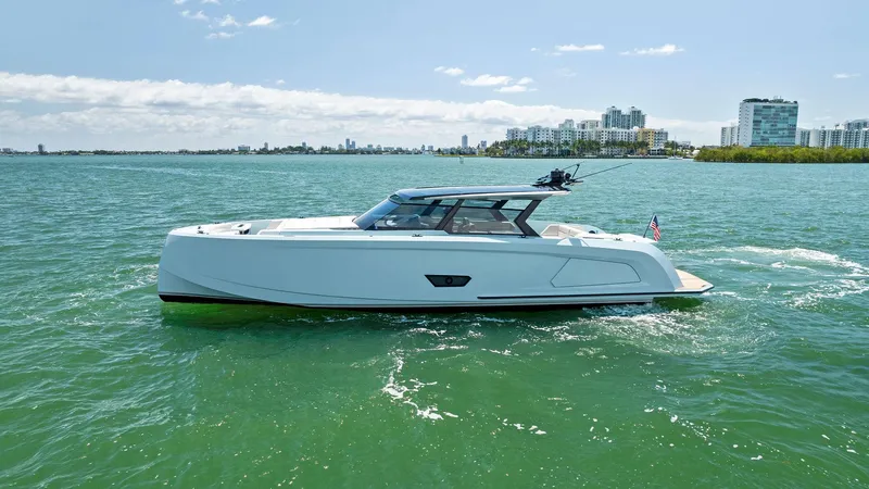Slide: The Image of 2022 Vanquish Yachts VQ58 cruising on a sunny day in a coastal city. - 2