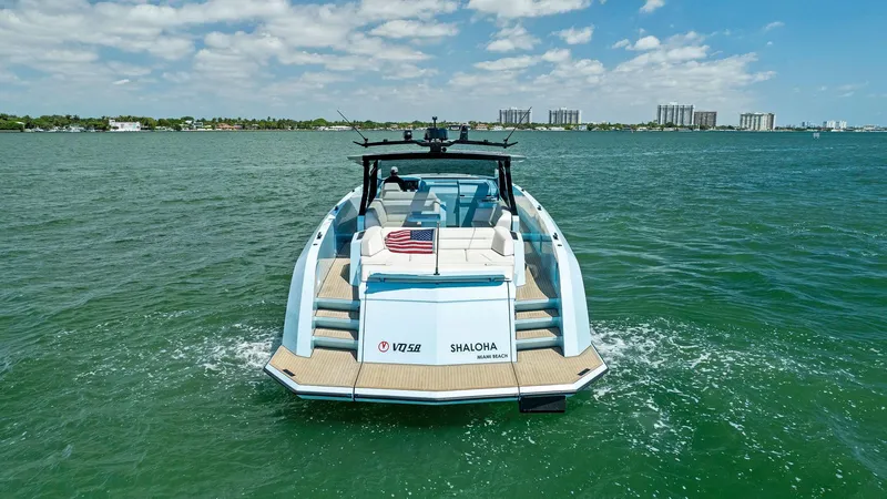 Slide: The Image of 2022 Vanquish Yachts VQ58 cruising on open water with city skyline in background. - 9
