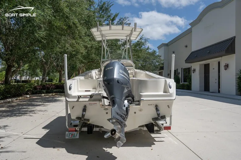 Slide: The Image of 2023 Sailfish 220 CC boat with outboard motor, parked outdoors on a sunny day. - 6