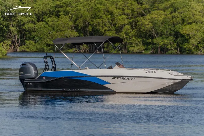 Slide: The Image of 2023 Starcraft SVX 211 OB boat on a calm lake with a forested background. - 3