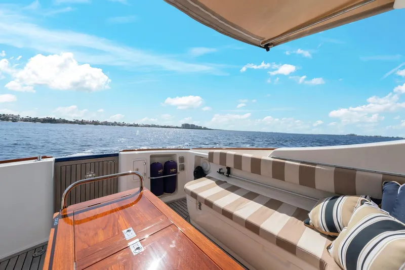 Slide: The Image of Luxury 2007 Oyster LD43 yacht deck with striped seating, wooden table, and ocean view. - 16