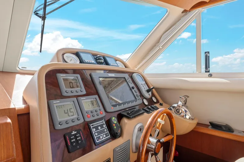 Slide: The Image of Control panel of a 2007 Oyster LD43 yacht with navigation instruments and steering wheel. - 44