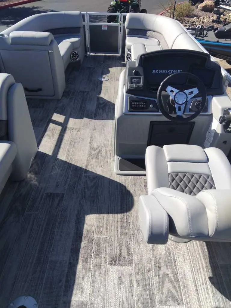 Slide: The Image of 2024 Ranger Reata 220C pontoon boat interior with modern seating and steering console. - 1