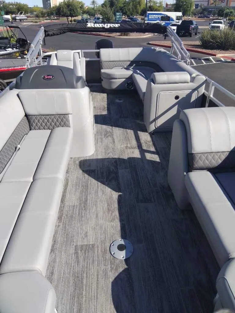 Slide: The Image of 2024 Ranger Reata 220C pontoon boat with spacious seating and modern interior design. - 2