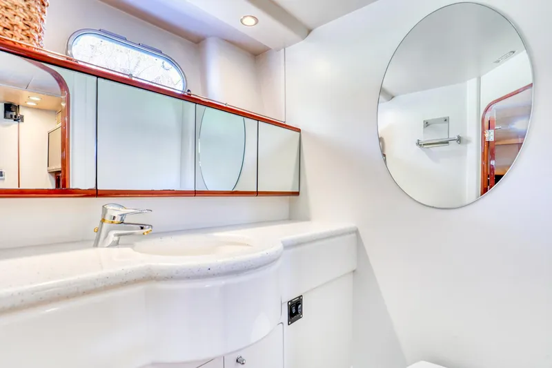 Slide: The Image of Luxurious bathroom in 2001 Viking Sport Cruisers Motoryacht with modern fixtures and round mirror. - 23