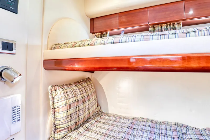 Slide: The Image of 2001 Viking Sport Cruisers Motoryacht cabin with plaid bedding and wooden bunk beds. - 27