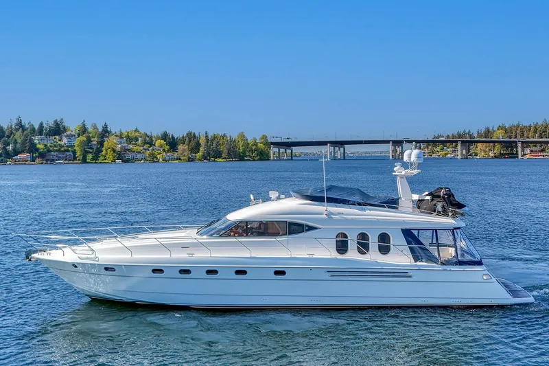Slide: The Image of 2001 Viking Sport Cruisers Motoryacht on a serene lake with a bridge in the background. - 6
