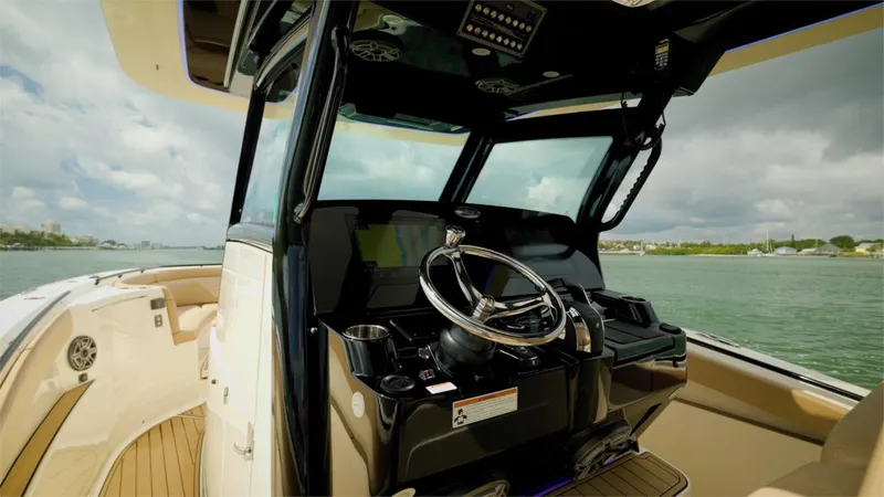 Slide: The Image of 2022 Scout 330 LXF boat helm with steering wheel and navigation controls. - 19