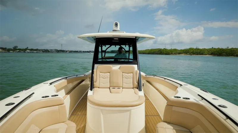 Slide: The Image of 2022 Scout 330 LXF boat on calm waters with luxurious seating. - 21