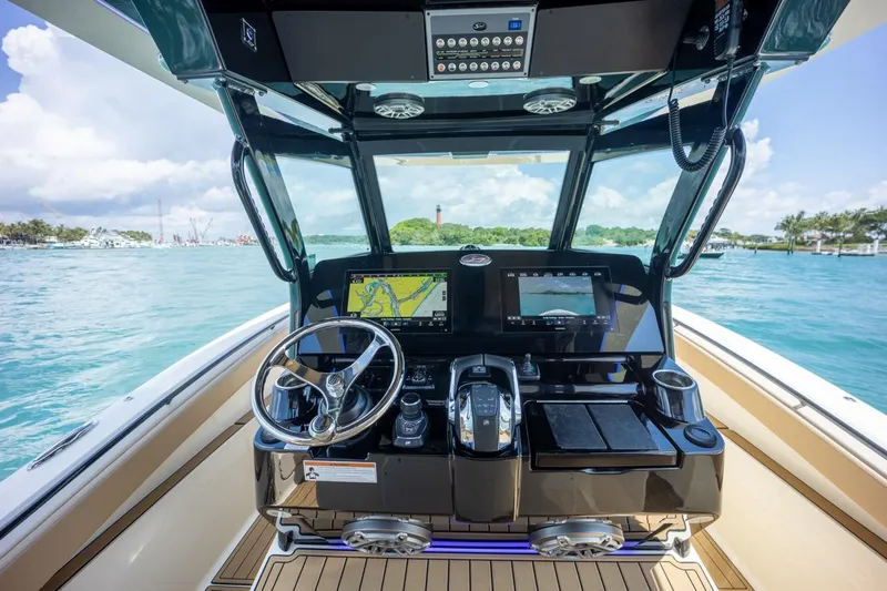 Slide: The Image of 2022 Scout 330 LXF boat dashboard with navigation screens on open water. - 4